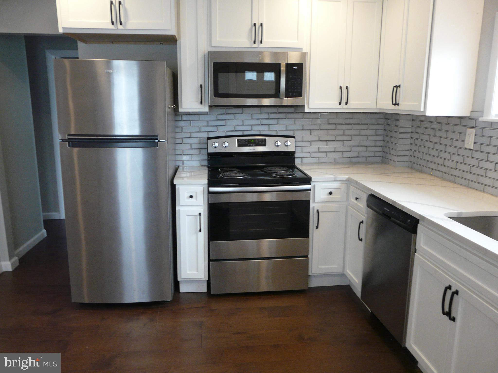 1009 Fuselage Avenue Middle River, MD 21220 - Photo 8 of 28 a kitchen with granite countertop a stainless steel stove and refrigerator