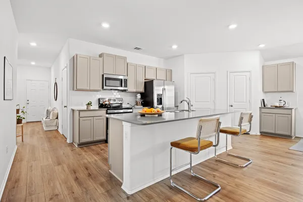 a kitchen with white cabinets and appliances