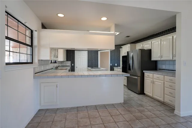 a kitchen with stainless steel appliances a refrigerator sink and microwave