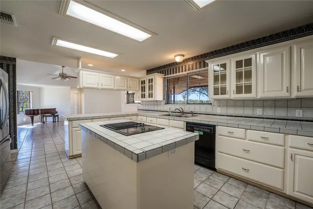 a kitchen with granite countertop a sink stove and cabinets