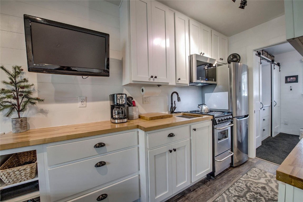 New fixtures, cabinets, and compact appliances, including over-the-range microwave, refrigerator, stove, vanity, lighting, garbage disposal.