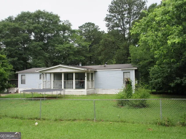 a front view of a house with a yard and trees