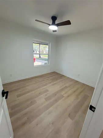 an empty room with windows and ceiling fan