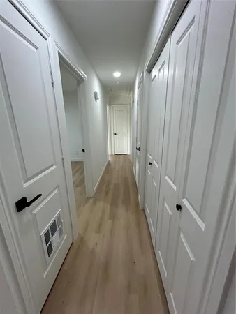 a view of a hallway with wooden floor and staircase
