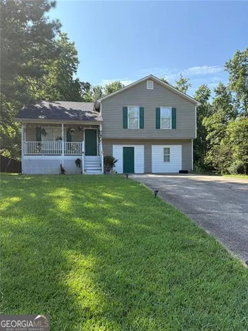 a view of a house with a yard and sitting area