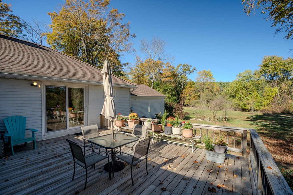 200 Long Plain Road Leverett, MA 01054 - Photo 29 of 40 a view of a patio with table and chairs and potted plants with wooden floor and fence