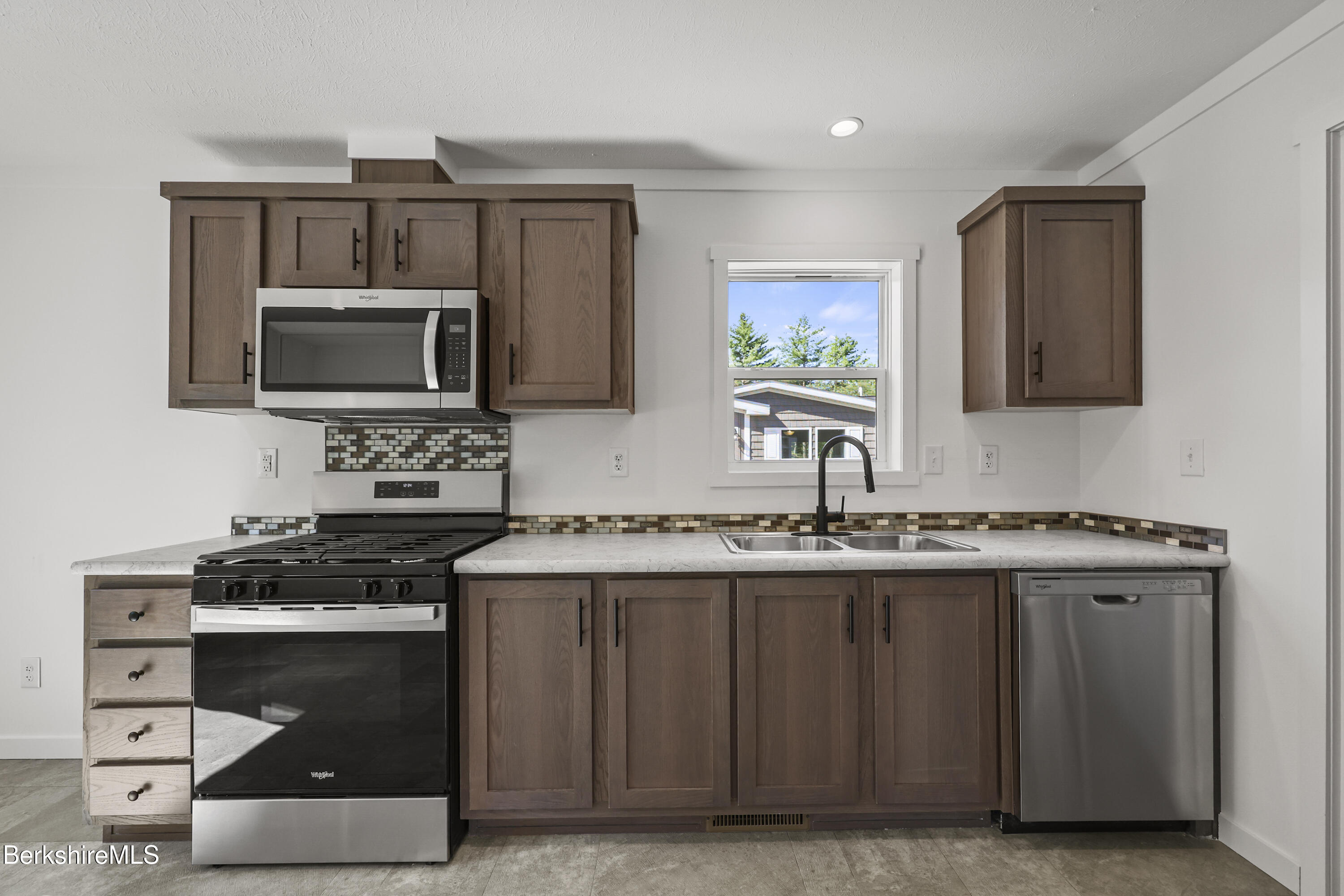 395 Cheshire Road, Unit 102 Pittsfield, MA 01201 - Photo 12 of 28 a kitchen with stainless steel appliances a stove microwave and sink