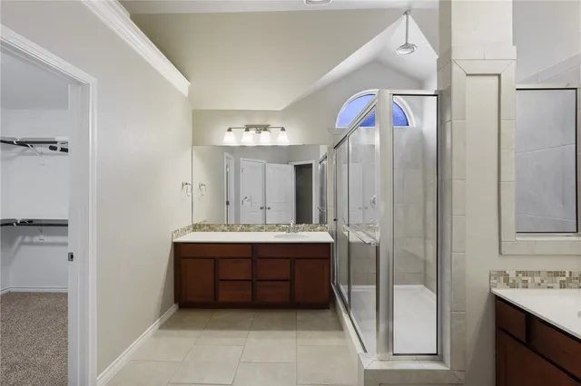a bathroom with double vanity and a mirror