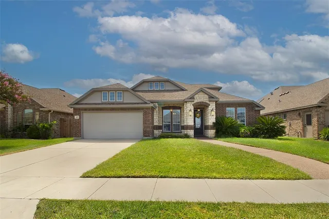 a front view of a house with a yard and garage