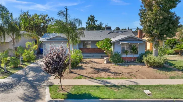 a view of a house with a yard and potted plants