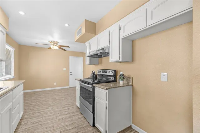 a kitchen with stainless steel appliances granite countertop a stove a sink and a refrigerator