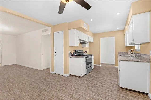 a kitchen with granite countertop a sink stainless steel appliances and cabinets