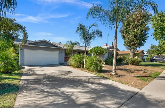 a front view of a house with a yard and a garage