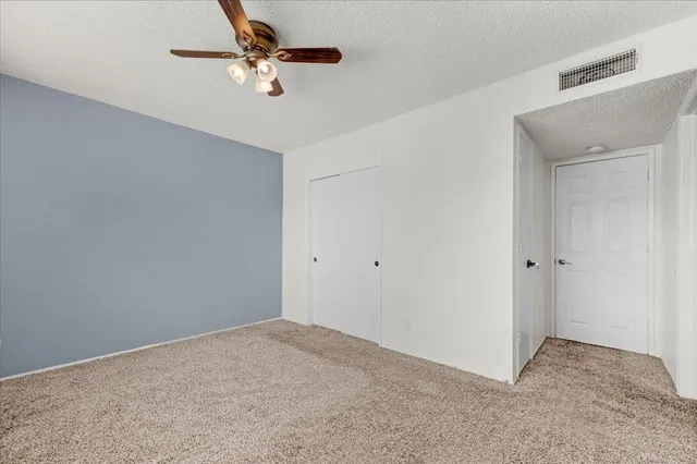 a view of a room with a ceiling fan