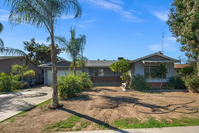 a front view of house with yard and trees around