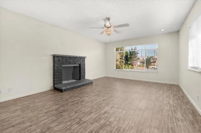 an empty room with windows and fireplace