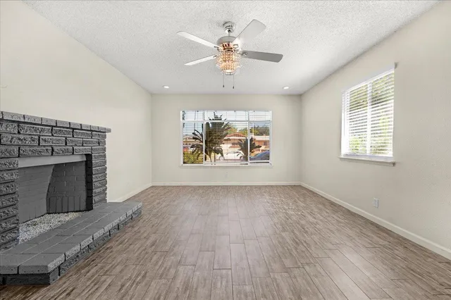 an empty room with windows and fireplace