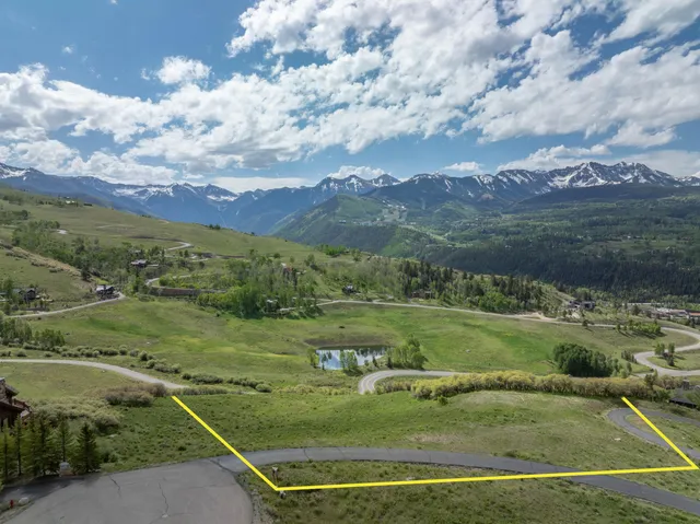 a view of a field with mountains in the background