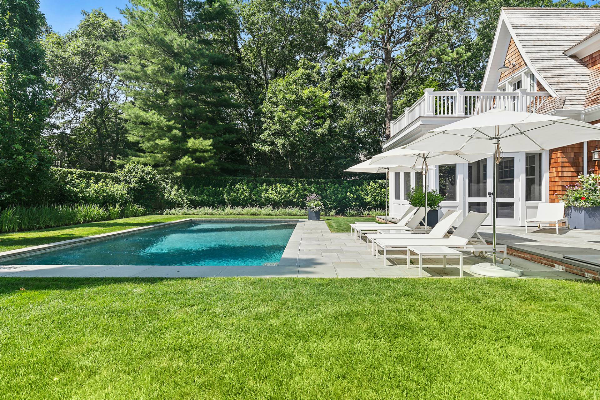 40 Roxbury Lane Wainscott, NY 11975 - Photo 25 of 29 a front view of a house with a yard table and chairs