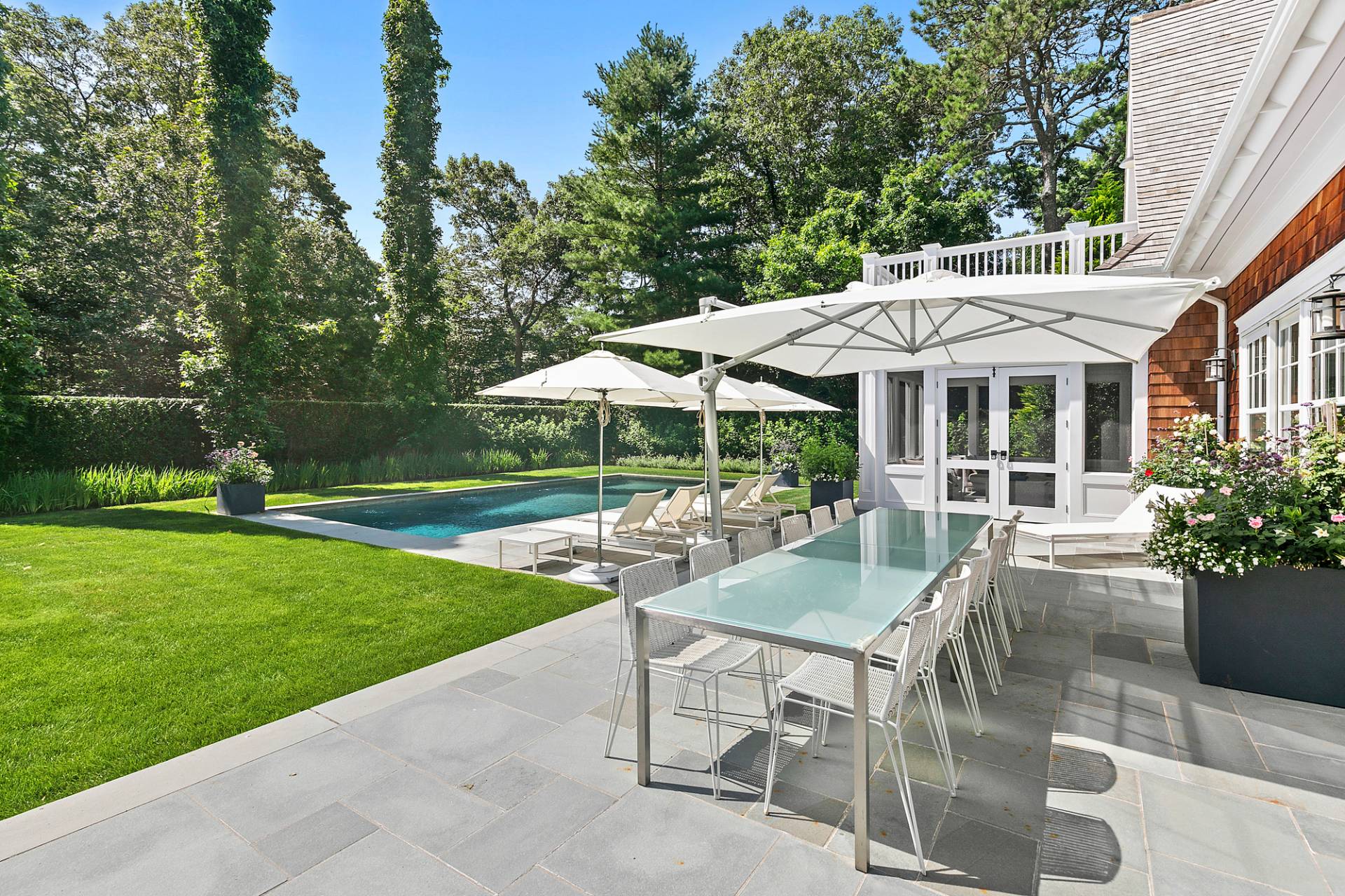 40 Roxbury Lane Wainscott, NY 11975 - Photo 26 of 29 a view of a patio with a table and chairs under an umbrella