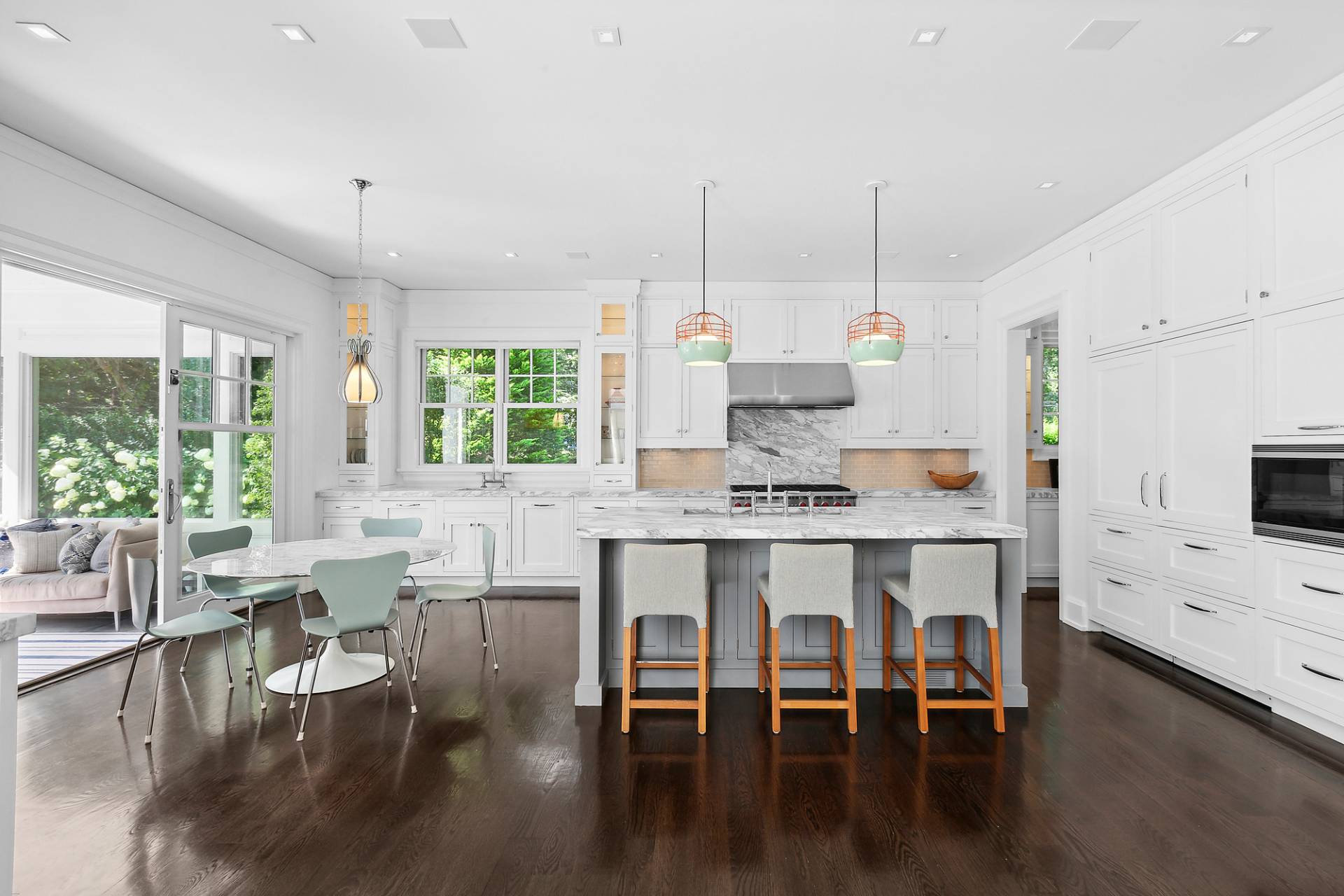 40 Roxbury Lane Wainscott, NY 11975 - Photo 10 of 29 a kitchen with stainless steel appliances granite countertop a stove a refrigerator a kitchen island a dining table and chairs with wooden floor