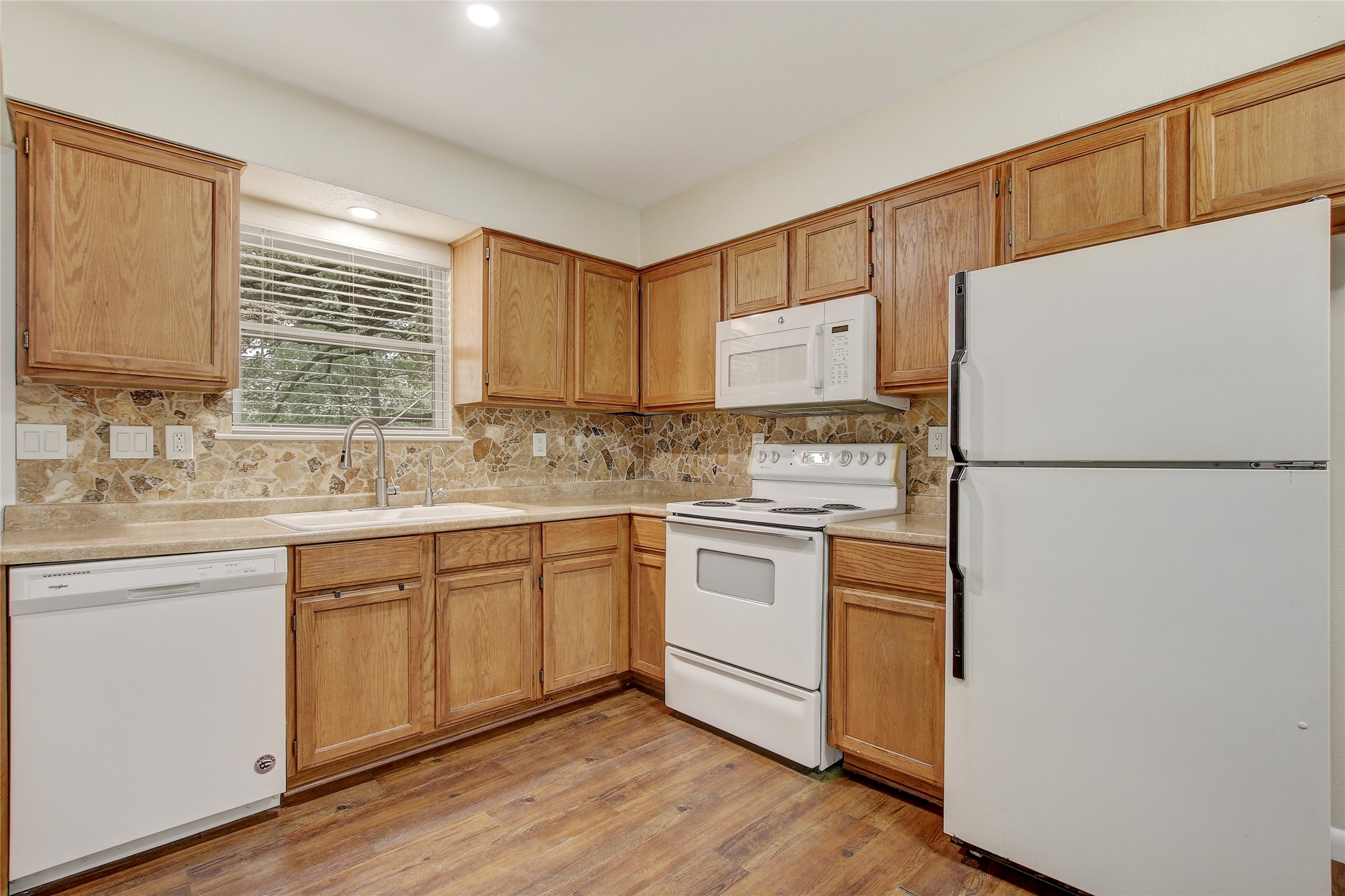 6902 Rifle Bend, Unit B Austin, TX 78736 - Photo 7 of 34 a kitchen with granite countertop a refrigerator a sink and white cabinets