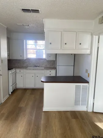 a large kitchen with cabinets and wooden floor