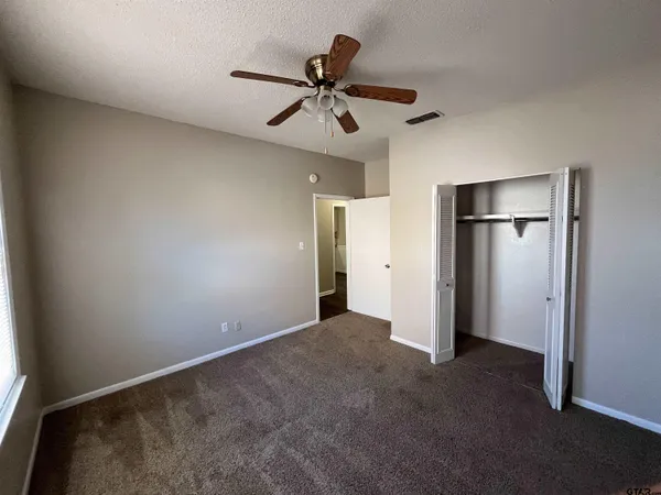 a view of an empty room with a ceiling fan