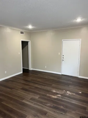 a view of an empty room with wooden floor