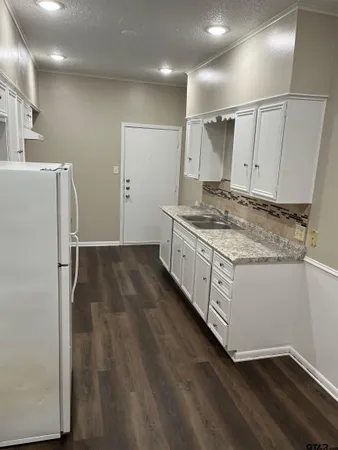 a kitchen with granite countertop a sink and a stove top oven