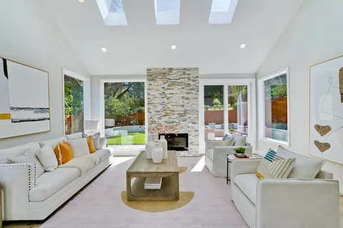 a living room with furniture fireplace and a large window