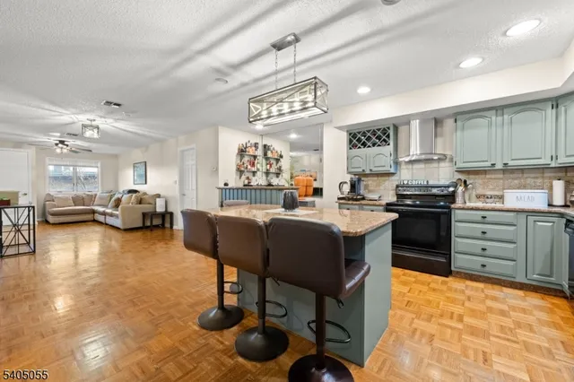 a kitchen with granite countertop a refrigerator a stove a sink and dishwasher with wooden floor