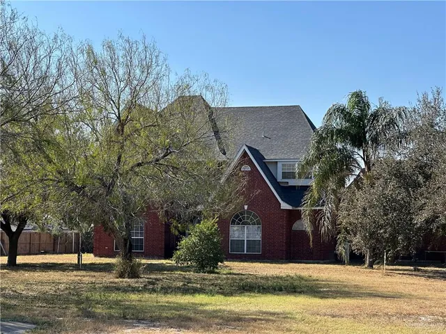 a front view of house with yard and trees around