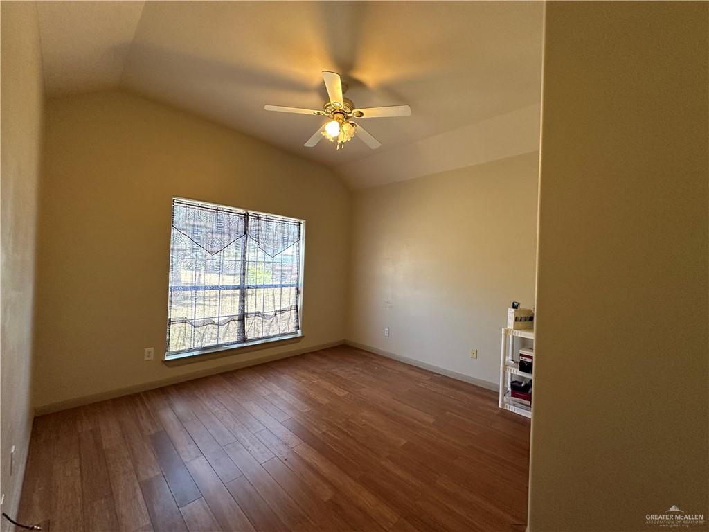 1215 South Tower Road Alamo, TX 78516 - Photo 19 of 41 an empty room with wooden floor fan and windows