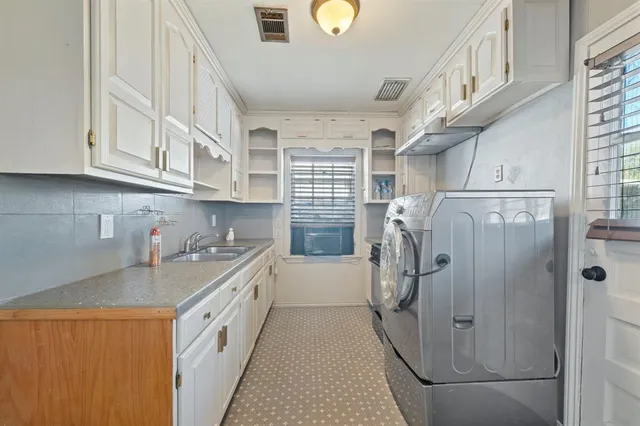 a kitchen with a sink a refrigerator and cabinets