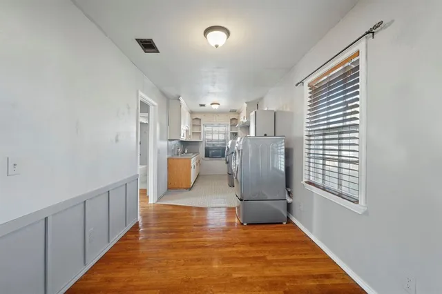 a view of a kitchen with kitchen island white cabinets and stainless steel appliances