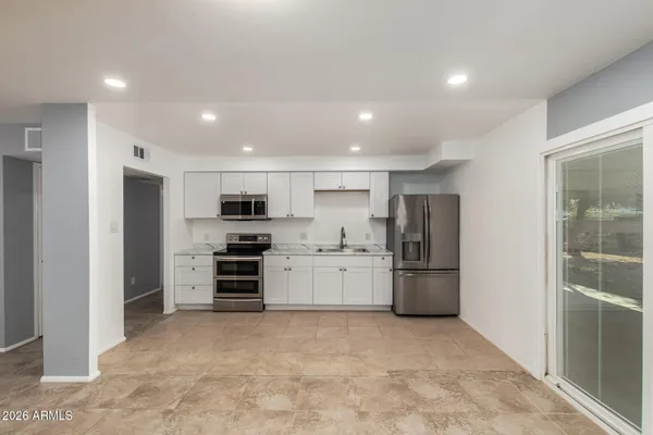 a large kitchen with a refrigerator and a stove top oven