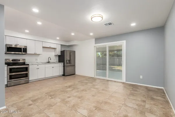a view of kitchen with stainless steel appliances granite countertop a stove a sink and a refrigerator