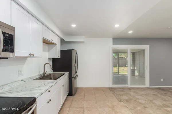 a kitchen with stainless steel appliances granite countertop a refrigerator and a sink