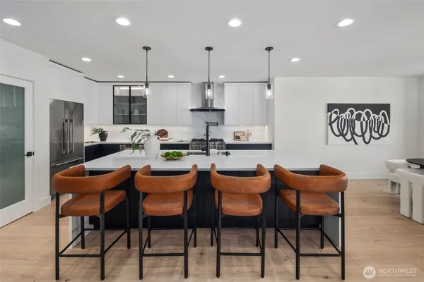 a dining room with stainless steel appliances kitchen island granite countertop a dining table chairs and a refrigerator