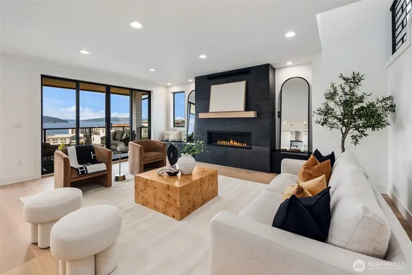 a living room with furniture fireplace and a large window