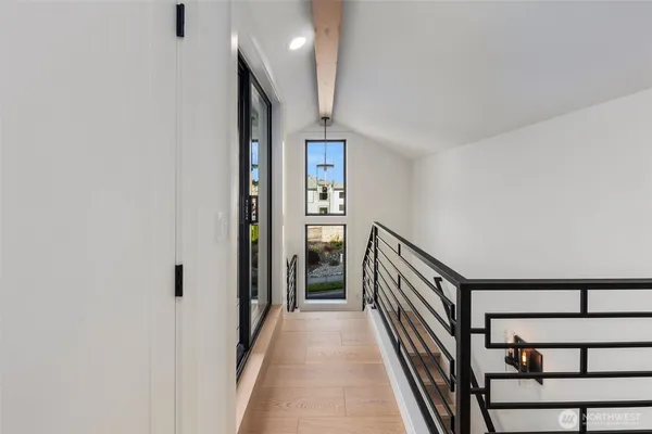 a view of a hallway with wooden floor and staircase