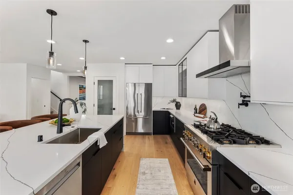 a kitchen with kitchen island a sink stove and refrigerator