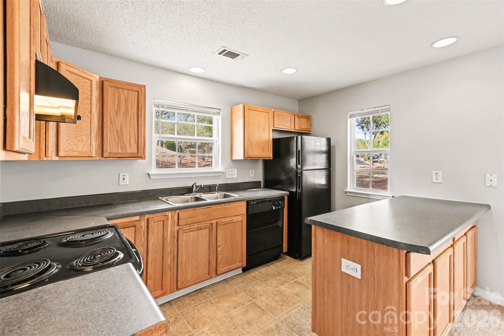 3201 Blythe Ridge Court Charlotte, NC 28213 - Photo 11 of 34 a kitchen with stainless steel appliances granite countertop a sink stove refrigerator and a window
