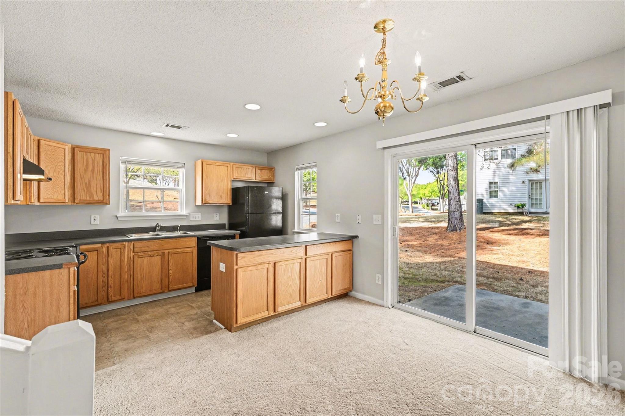 3201 Blythe Ridge Court Charlotte, NC 28213 - Photo 12 of 34 a large kitchen with stainless steel appliances granite countertop a stove top oven a sink dishwasher a dining table and chairs with outer view