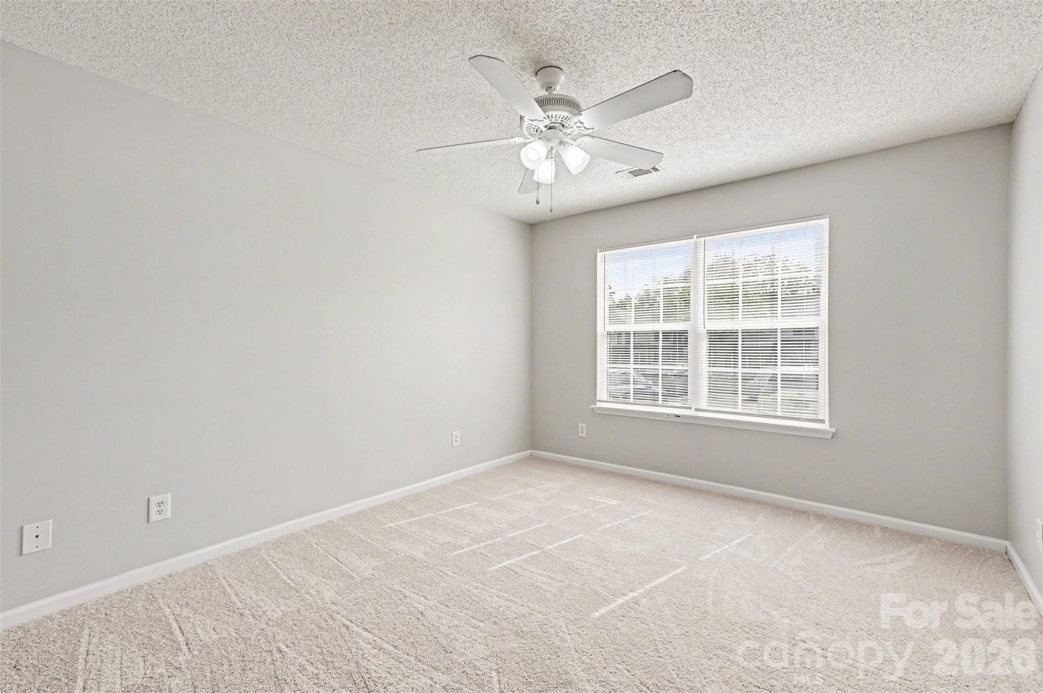 3201 Blythe Ridge Court Charlotte, NC 28213 - Photo 17 of 34 an empty room with chandelier fan and windows