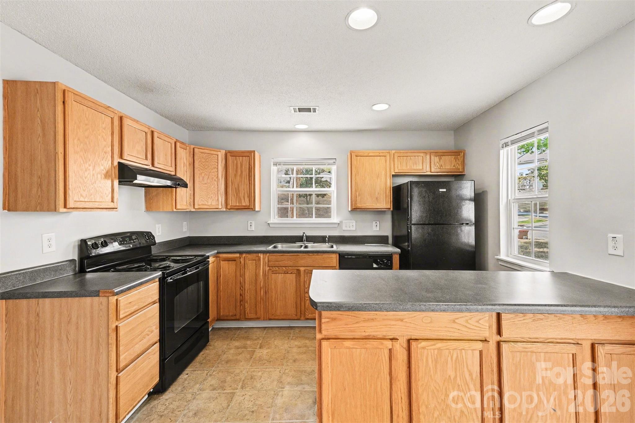 3201 Blythe Ridge Court Charlotte, NC 28213 - Photo 10 of 34 a kitchen with granite countertop a refrigerator a stove a sink a counter space and cabinets