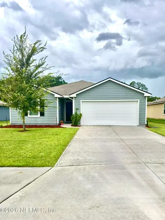 front view of a house with a yard and a garage