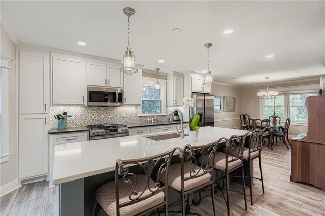 a kitchen with sink stove and refrigerator