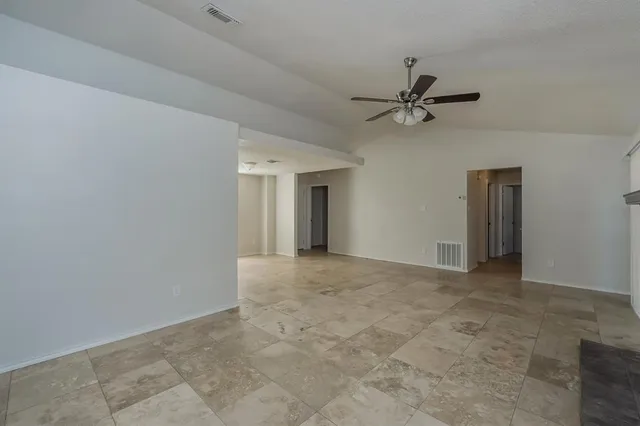 an empty room with closet and a ceiling fan